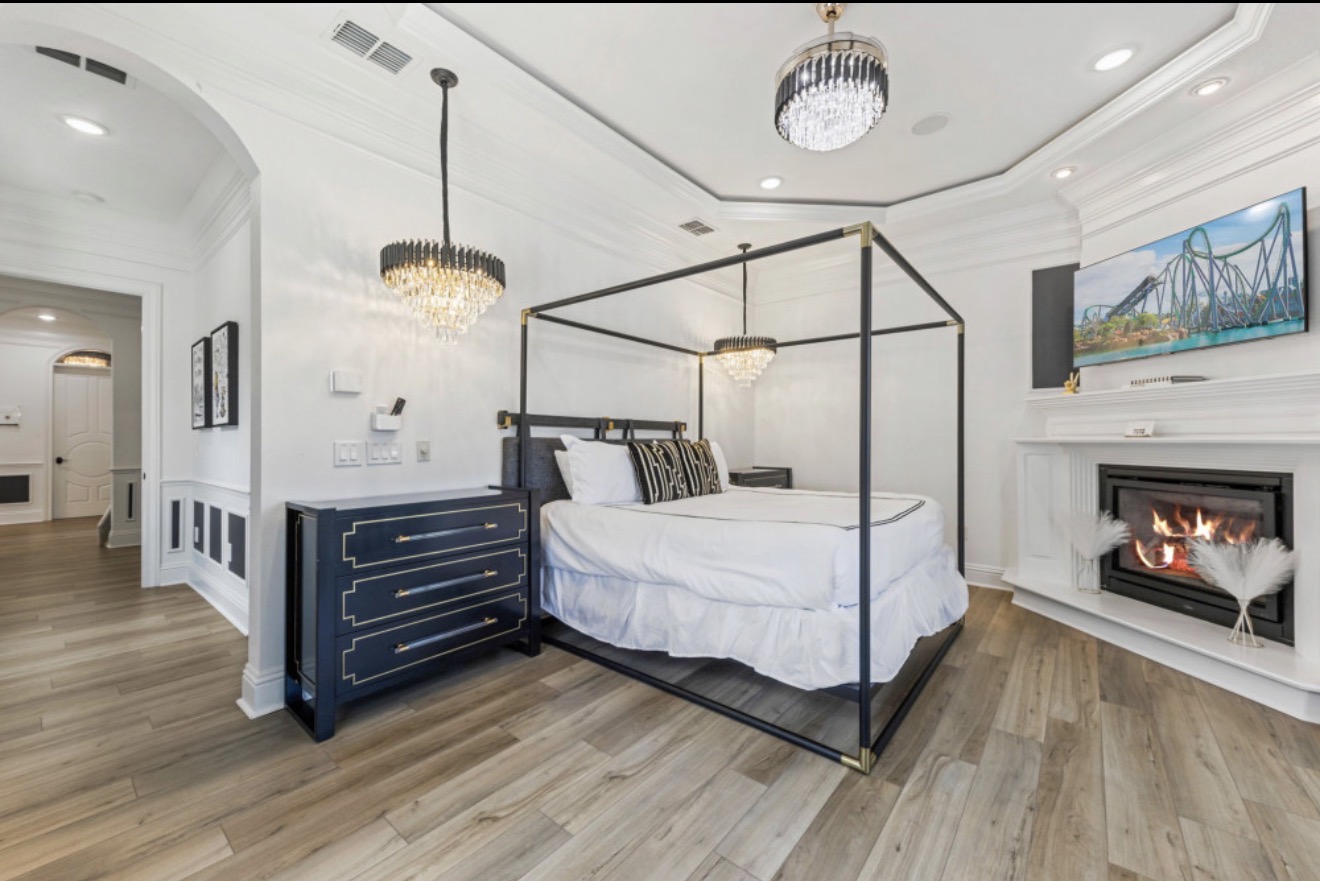 Elegant premier suite with a four-poster bed, chandelier, and fireplace