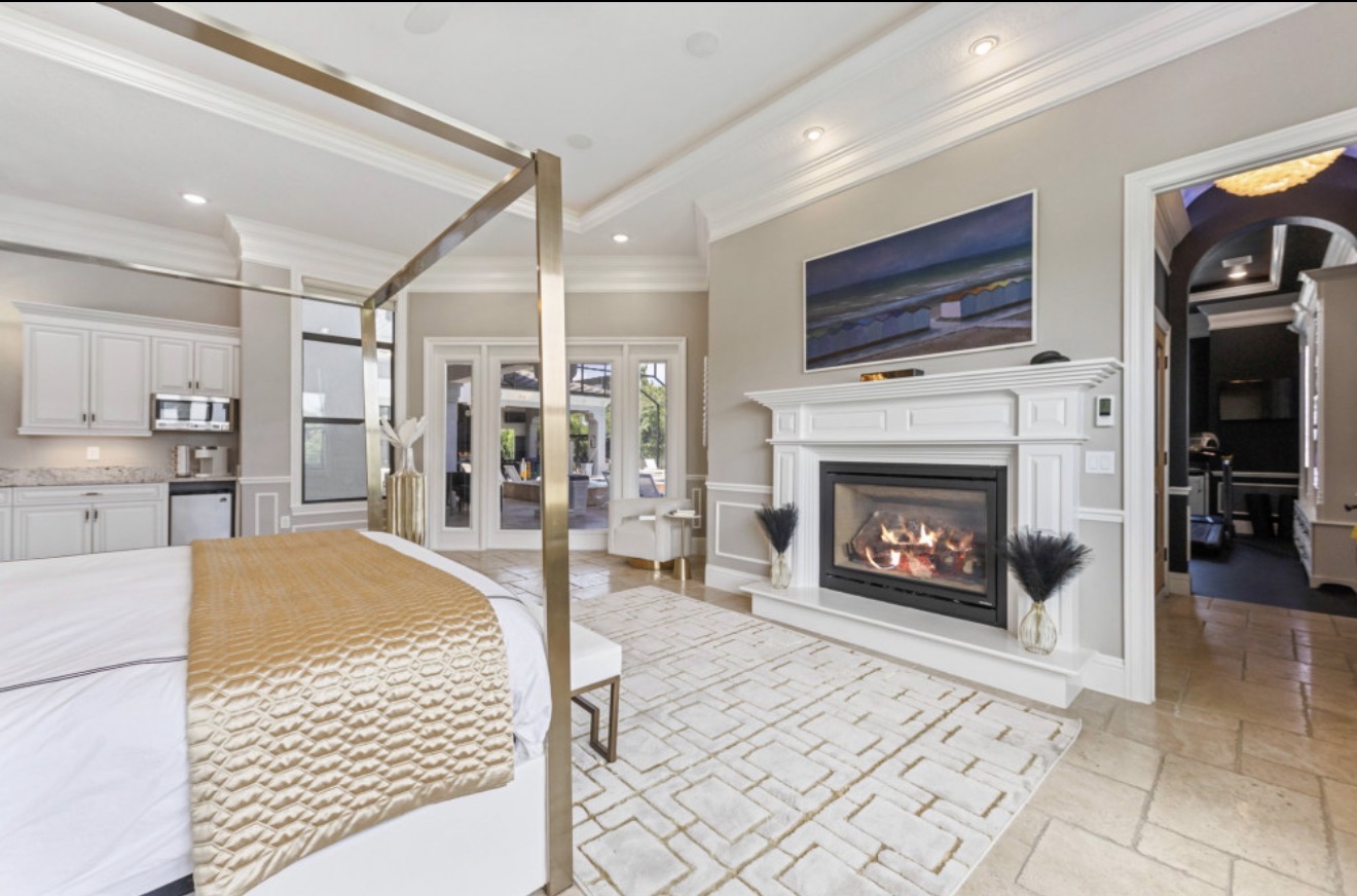 Private villa suite with a fireplace and patio doors
